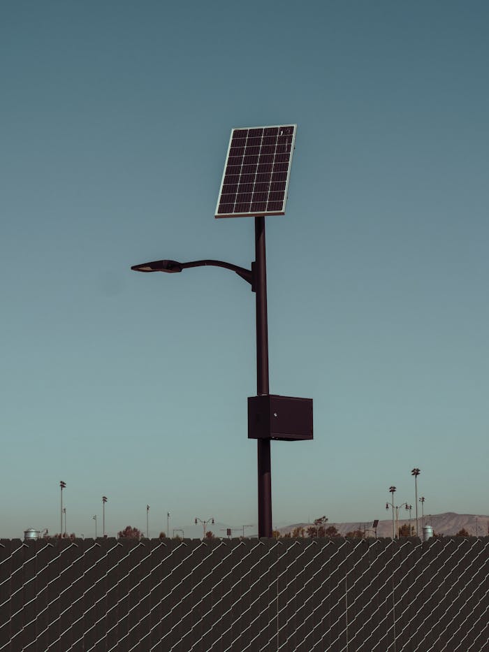 A solar-powered street light stands tall against a clear blue sky, symbolizing renewable energy.