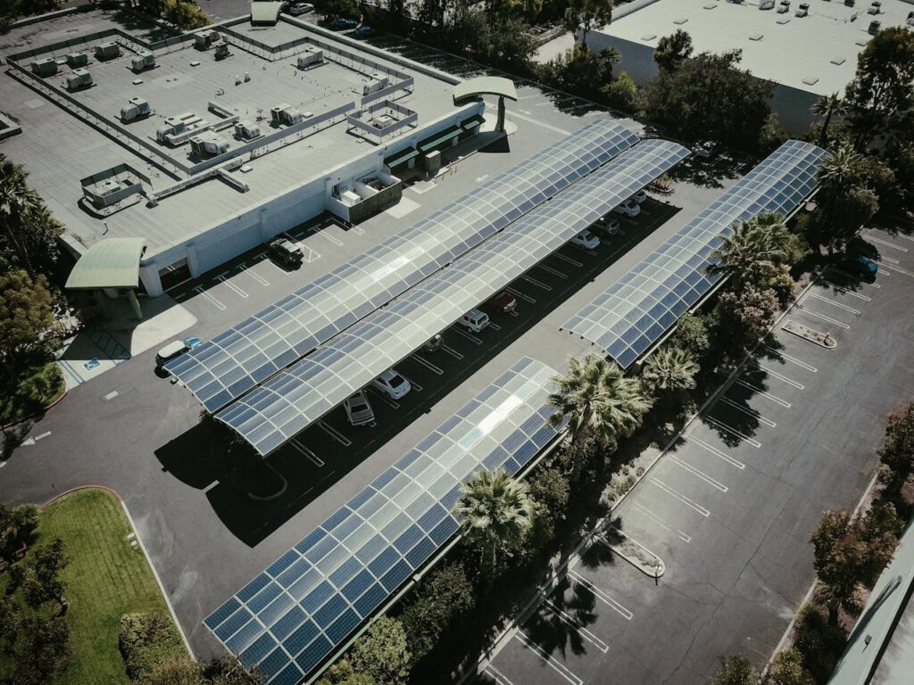 Aerial view of solar panels on a parking lot roof, showcasing renewable energy.